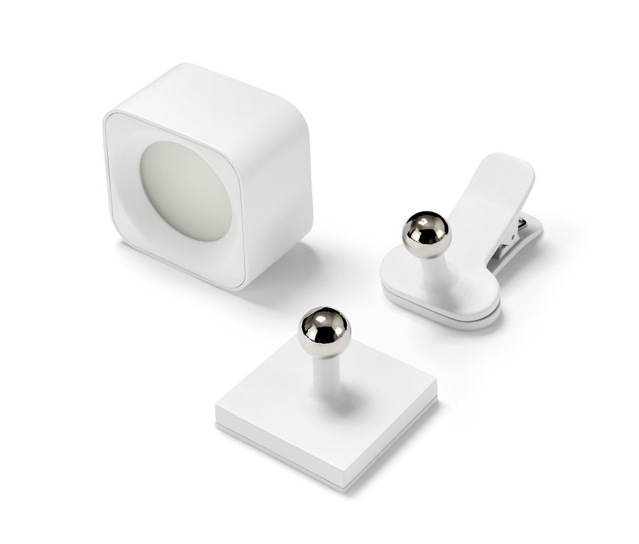 Egy LED-es akkumulátoros fali lámpa, egy mágneses tartó és egy klipsz fehér háttér előtt.