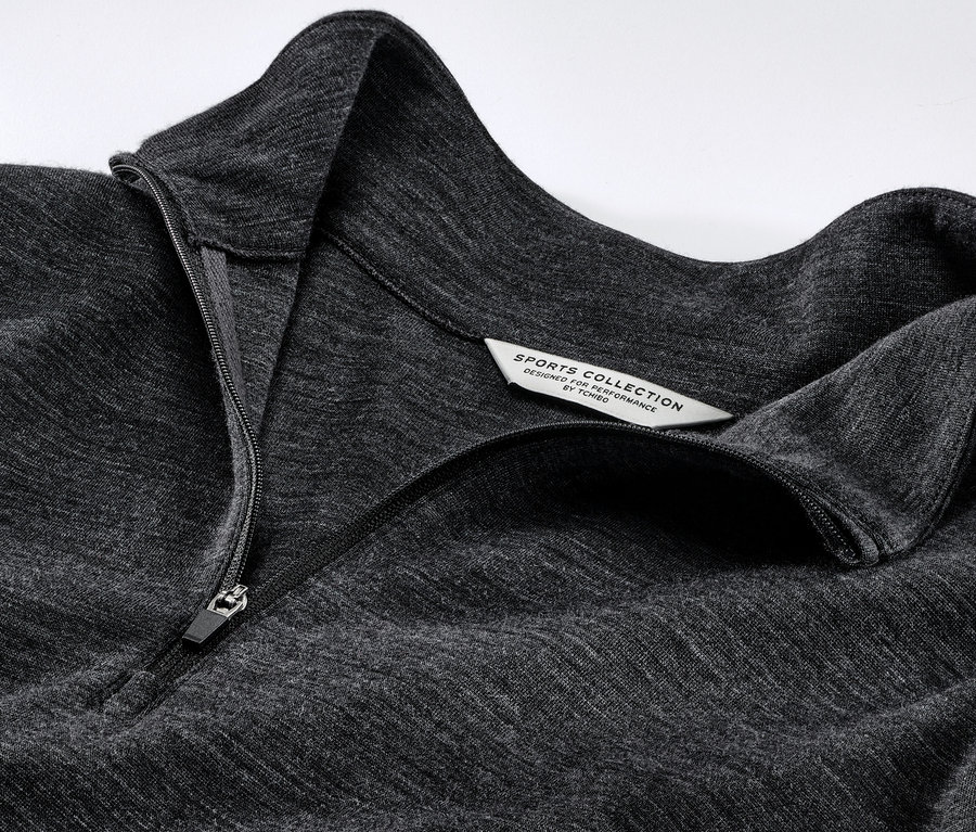 Egy szürke, RWS minősített gyapjúval készült, cipzáras multifunkcionális felső részletfotója.