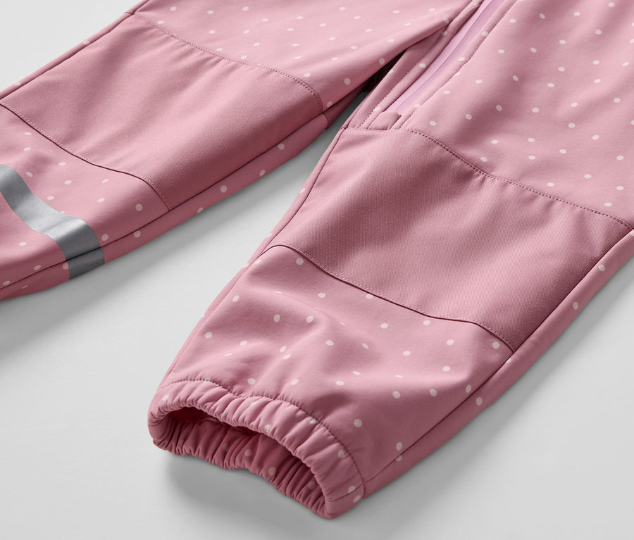 Egy gyermek softshell kezeslábas részlete fehér pöttyökkel.