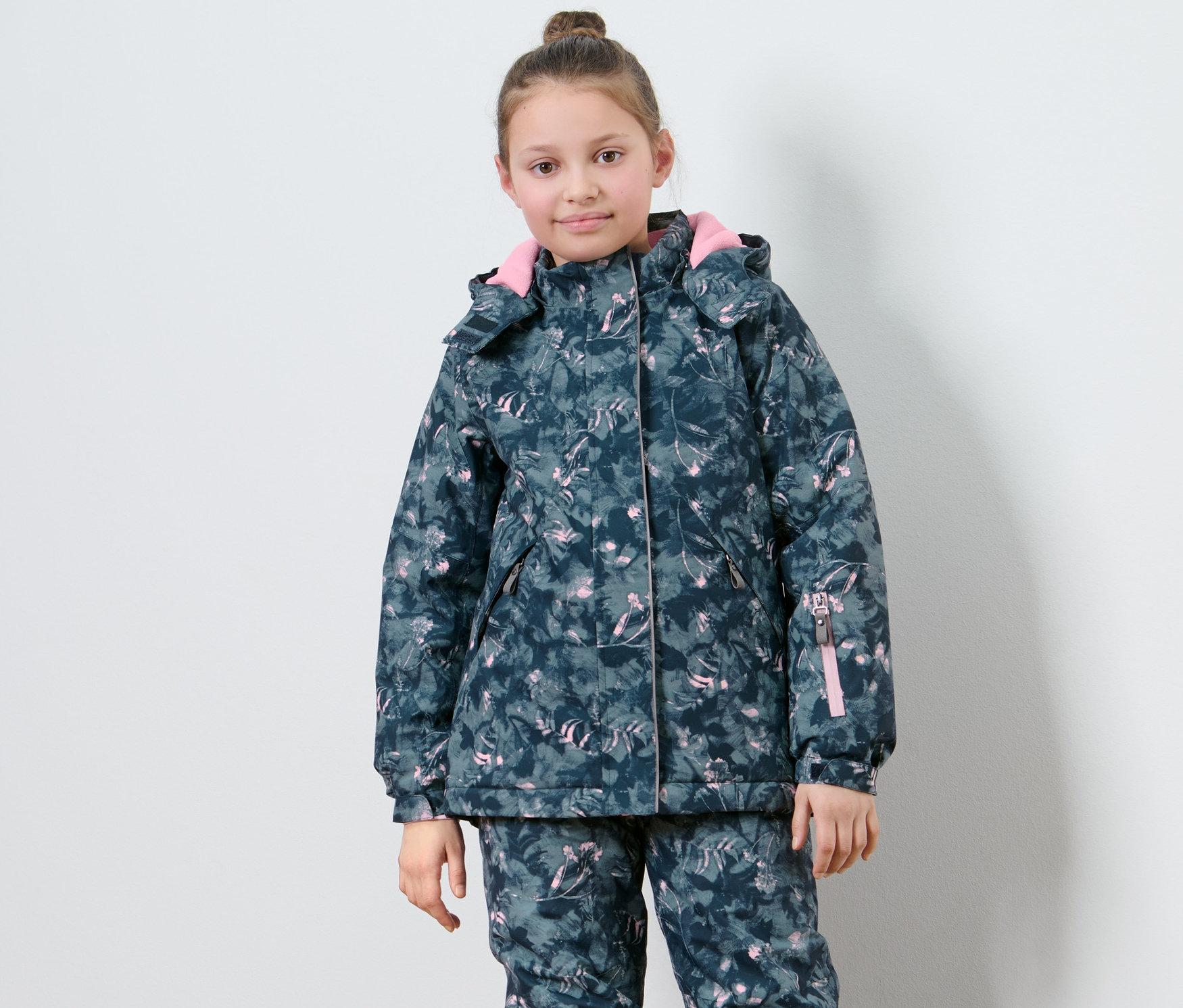 Kislány mintás síkabátban pózol.