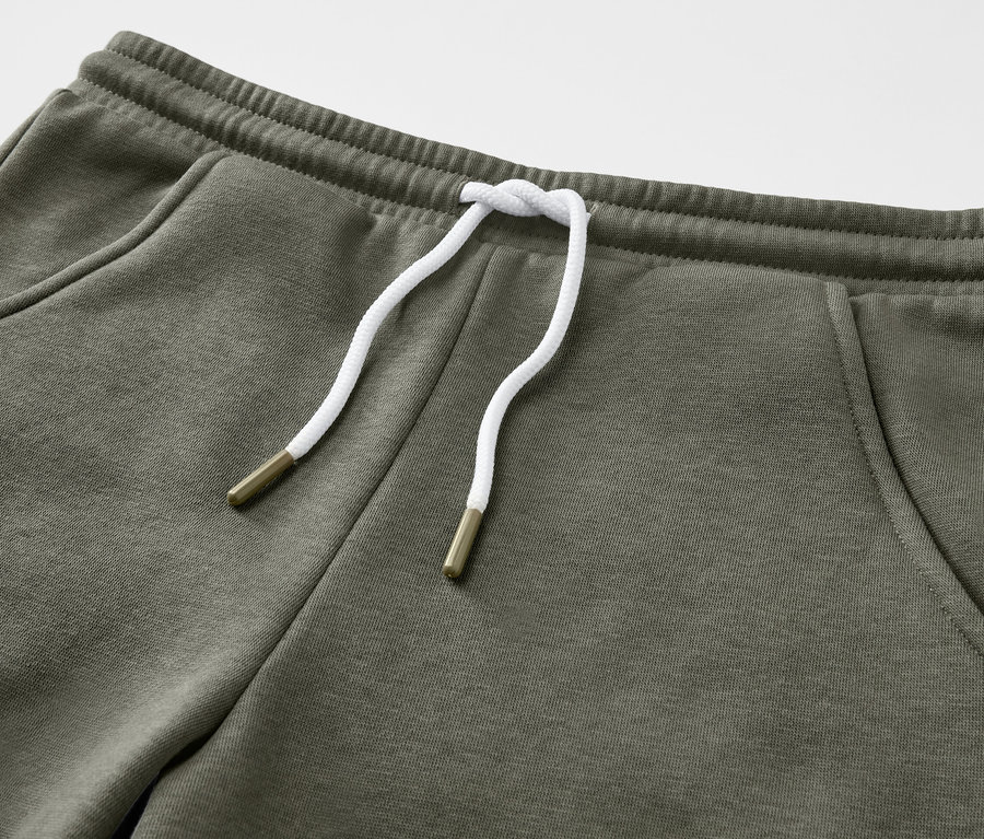 Közelkép egy olívazöld, húzózsinóros 2 szabadidősort gyerekeknek termékről.