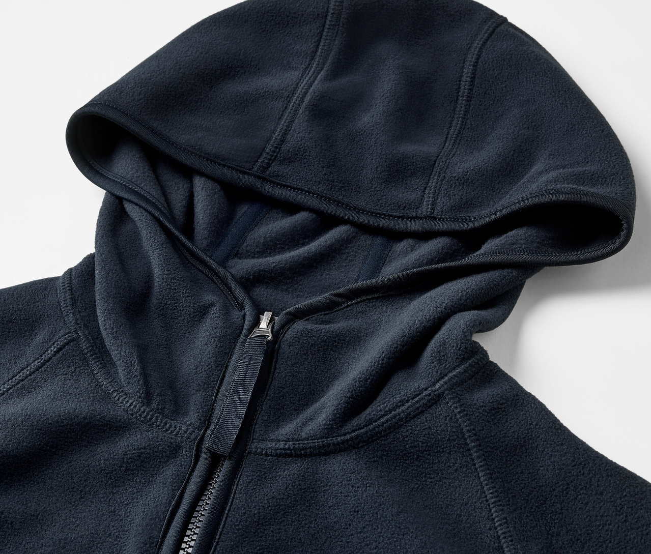 Egy kék, cipzáras, kapucnis polárfelső részletgazdag képe.