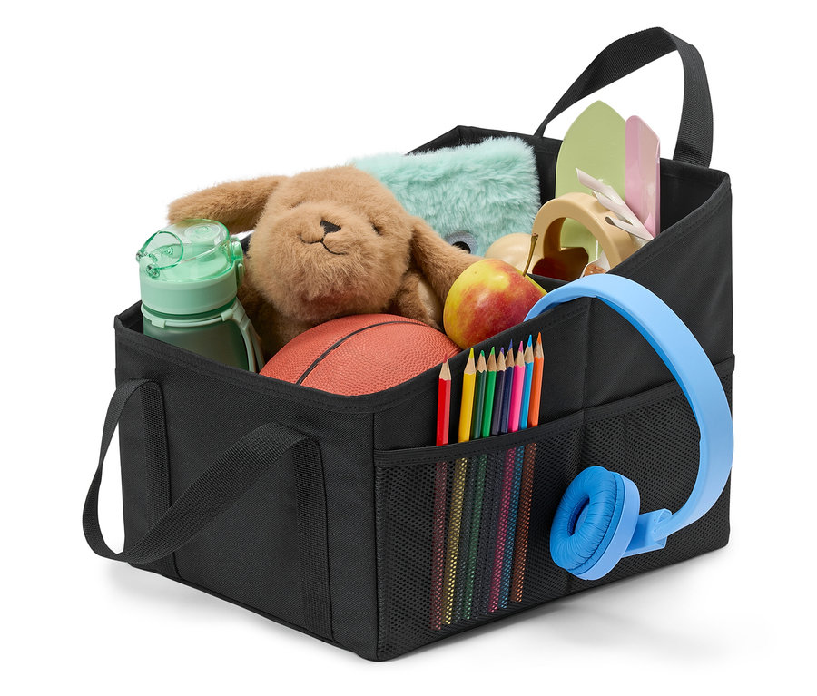 Egy fekete tároló játékokkal, színes ceruzákkal, fejhallgatóval és egy almával.