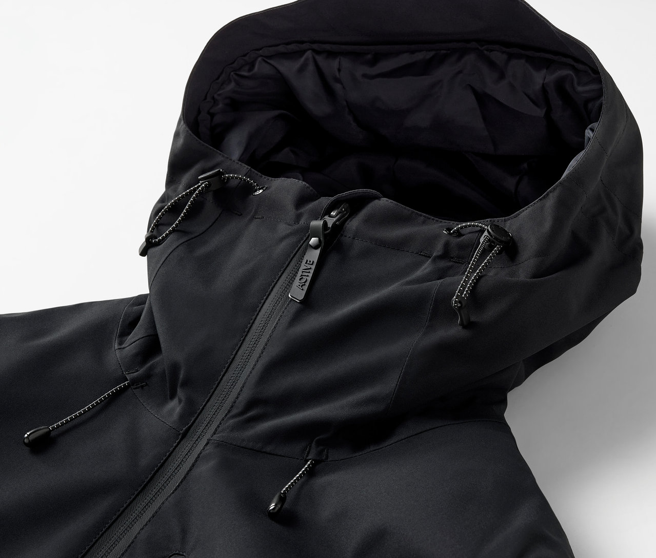 Egy fekete kapucnis dzseki részlete, cipzárral.