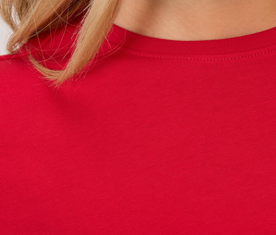 Egy piros póló részlete egy nőn.