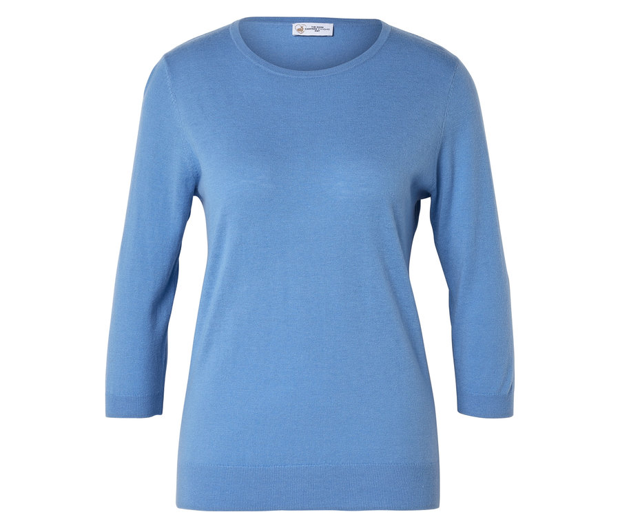 Egy világoskék, háromnegyedes ujjú pulóver fekszik egy fehér felületen.