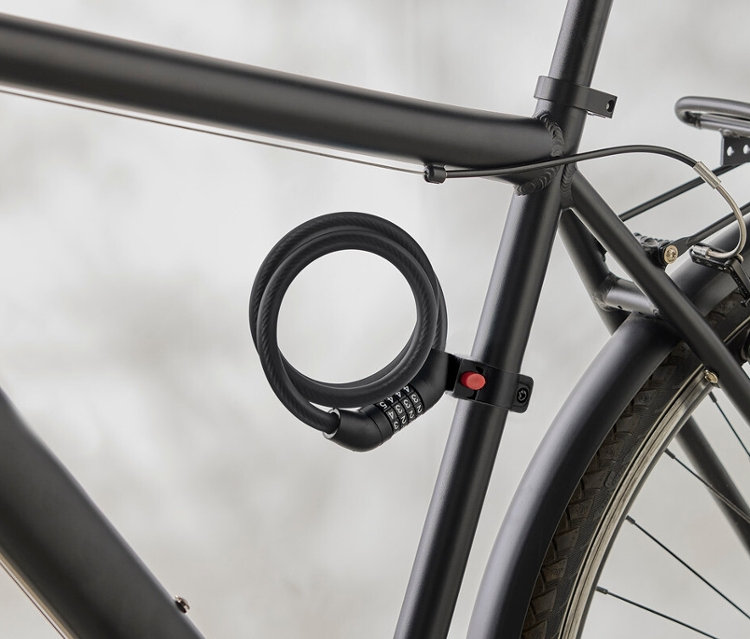 Egy fekete kerékpárváz közeli képe, a vázhoz rögzített spirálkóddal.