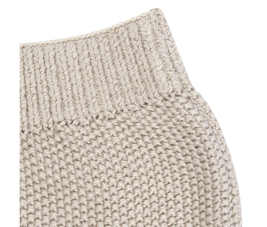 Közelkép egy világos bézs Sterntaler Baby-Strickhose-ról, bordázott derékrésszel és texturált kötött mintával.