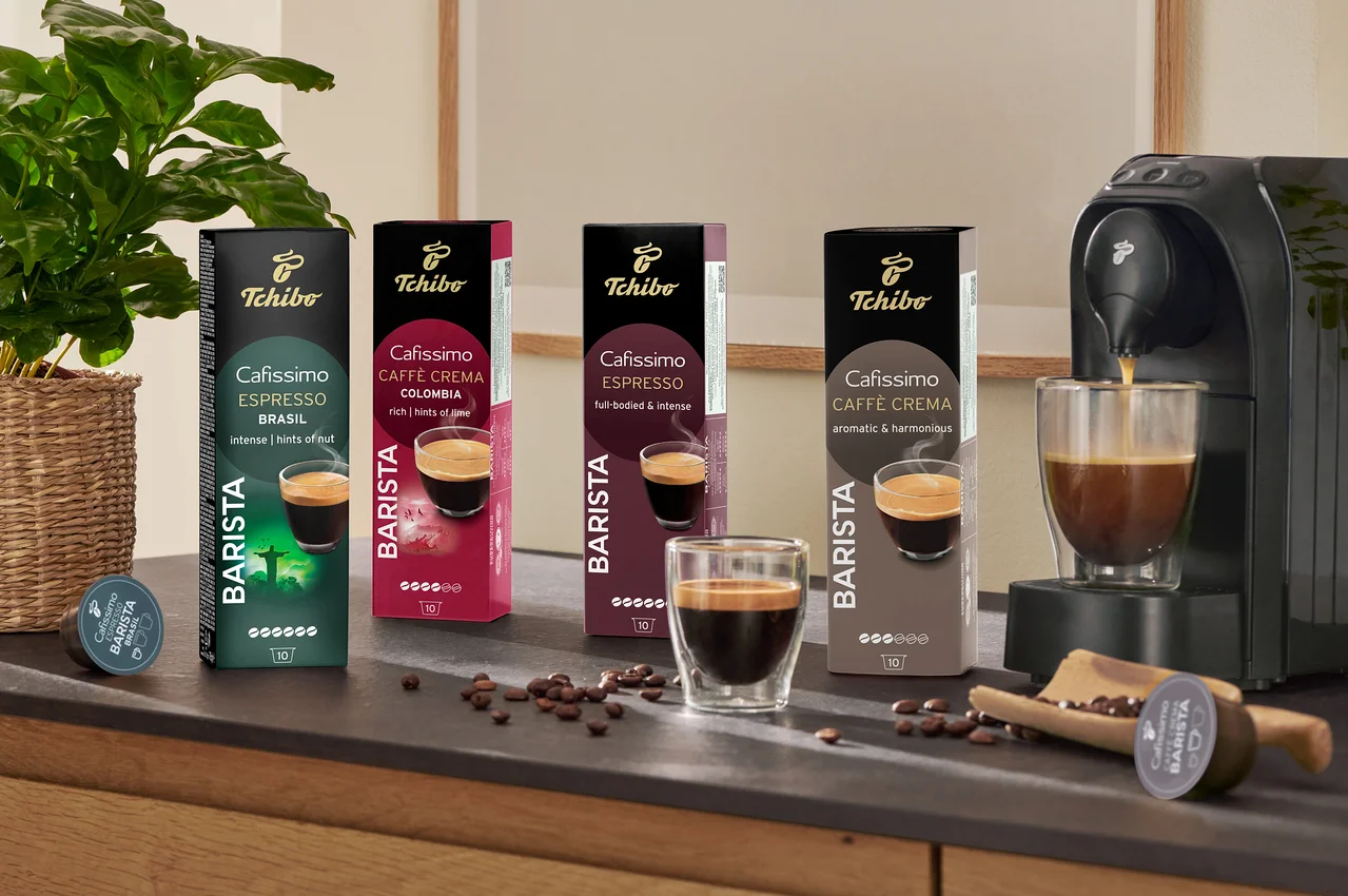 A pulton Cafissimo Barista Edition Espresso kapszulák és egy kávéfőző látható egy presszókávéscsészével.
