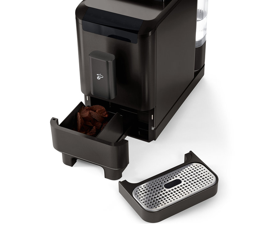 Közelkép a »Esperto2 Caffè« automata kávéfőzőről Granite Black színben, kihúzott kávézacc-tartállyal és csepptálcával.