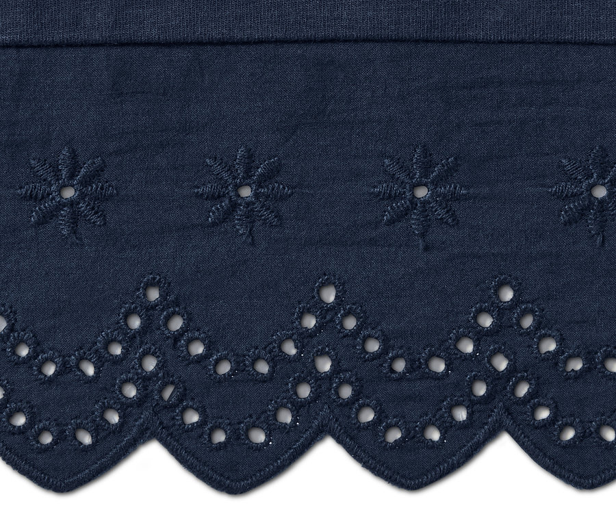 A sötétkék, hímzett női 3/4-es bőszárú nadrág részlete.