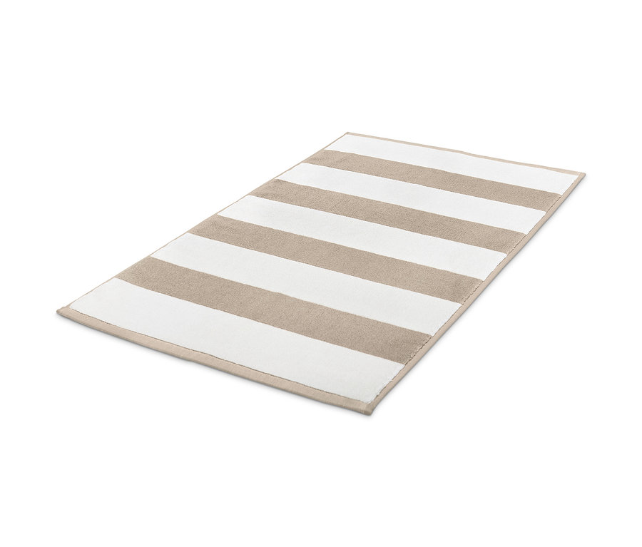 Egy bézs-fehér csíkos fürdőszobaszőnyeg.