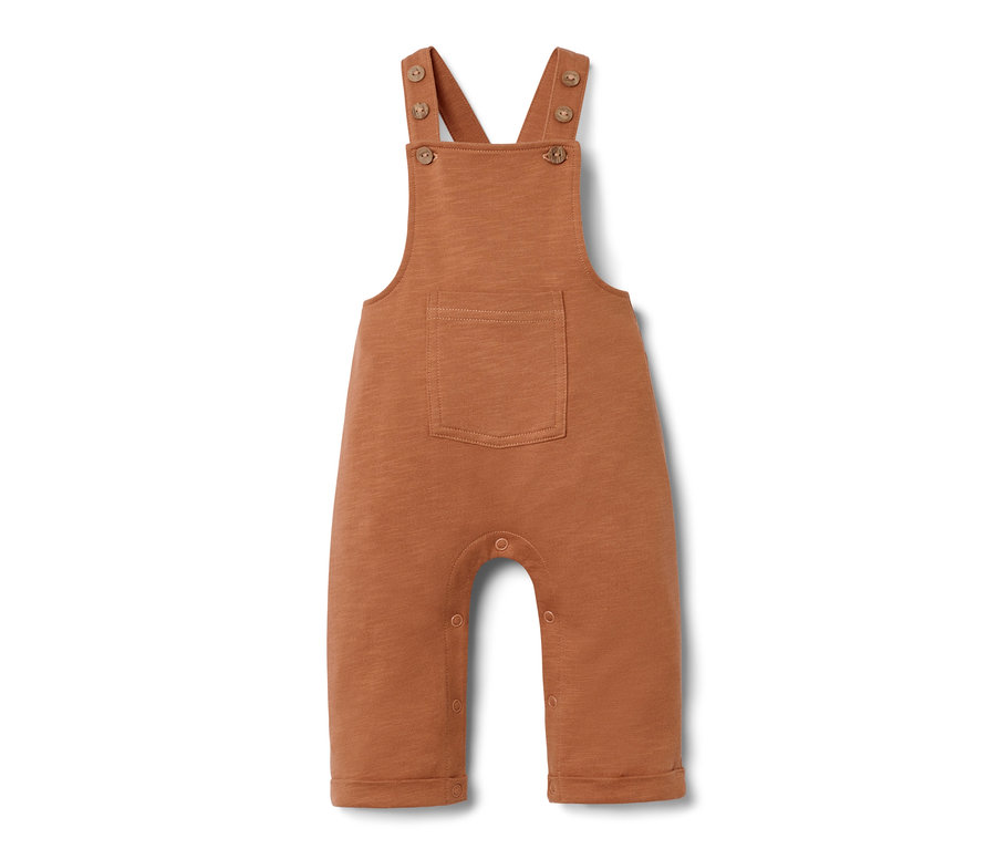 Egy barna kisgyerek kantáros nadrág középen zsebbel.