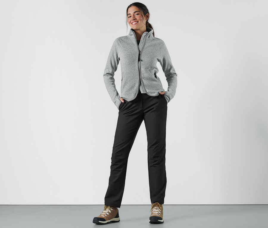 Nő áll a zsebében a softshell nadrággal.