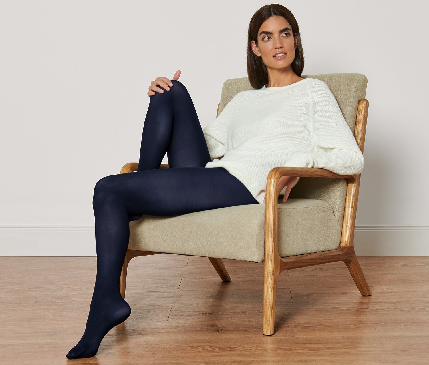 Nő ül a székben, sötétkék harisnyát visel a 2 női harisnya szettből.