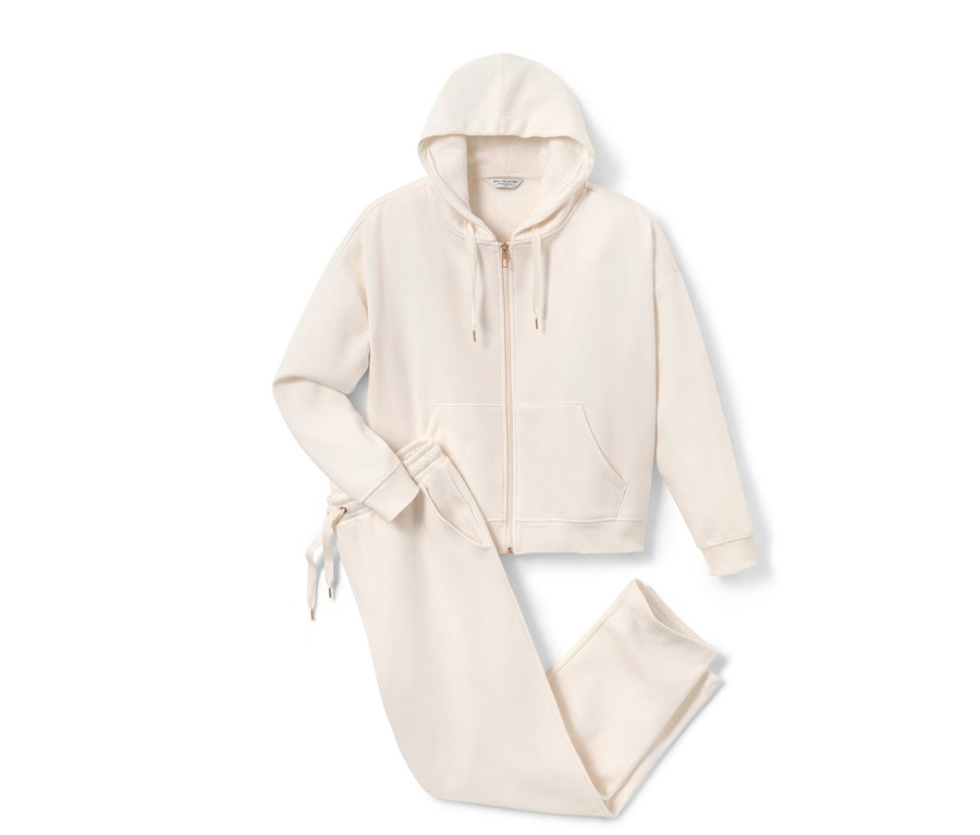 Egy krémszínű női szabadidő szett kapucnis felsővel és nadrággal.