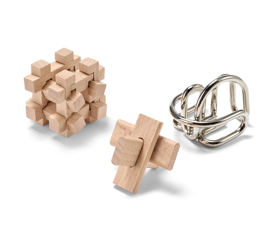 Három ördöglakat, fából és fémből, fehér háttérrel. Kettő fából, egy fémből.