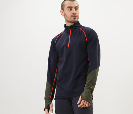 Férfi sötétkék funkcionális termofelsőt és leggingset visel, és pózol.