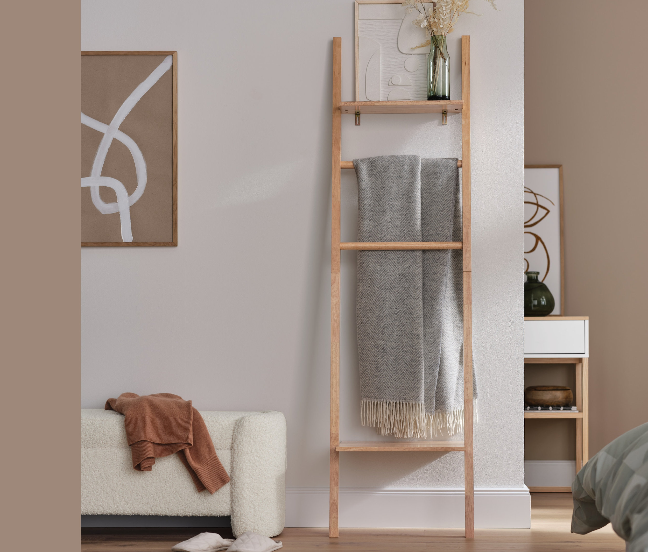 Egy kárpitozott ülőpad és egy létrás polc egy nappaliban.