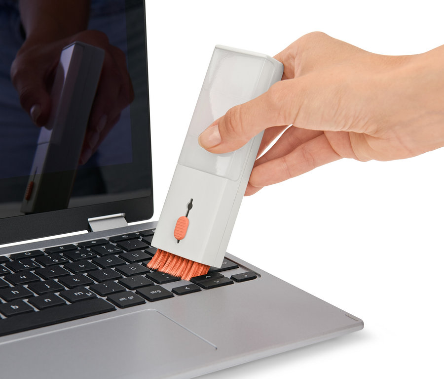 Egy kéz egy laptop billentyűzetét tisztítja egy 4 az 1-ben elektronikai eszköz tisztítóval.