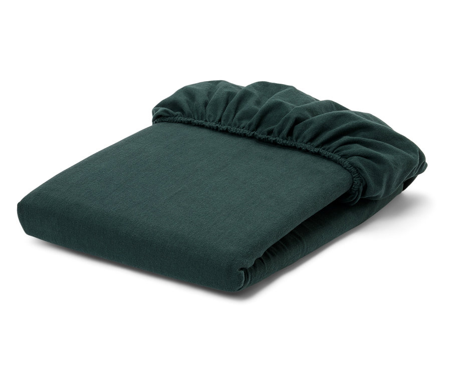 Összehajtott zöld gumis lepedő fehér háttérrel.