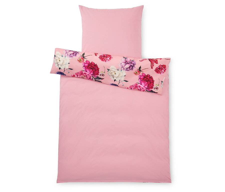Felülnézet egy rózsaszín paplanhuzatról és egy párnahuzatról, a párnahuzaton és a paplanhuzat felső felén virágmintával.