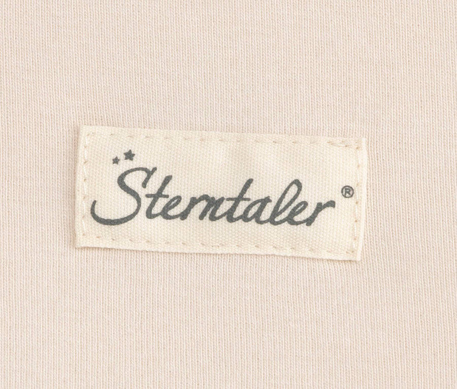 „Sterntaler” márkajelzés világosbézs anyagon, valószínűleg egy bébi belső hálózsákról.