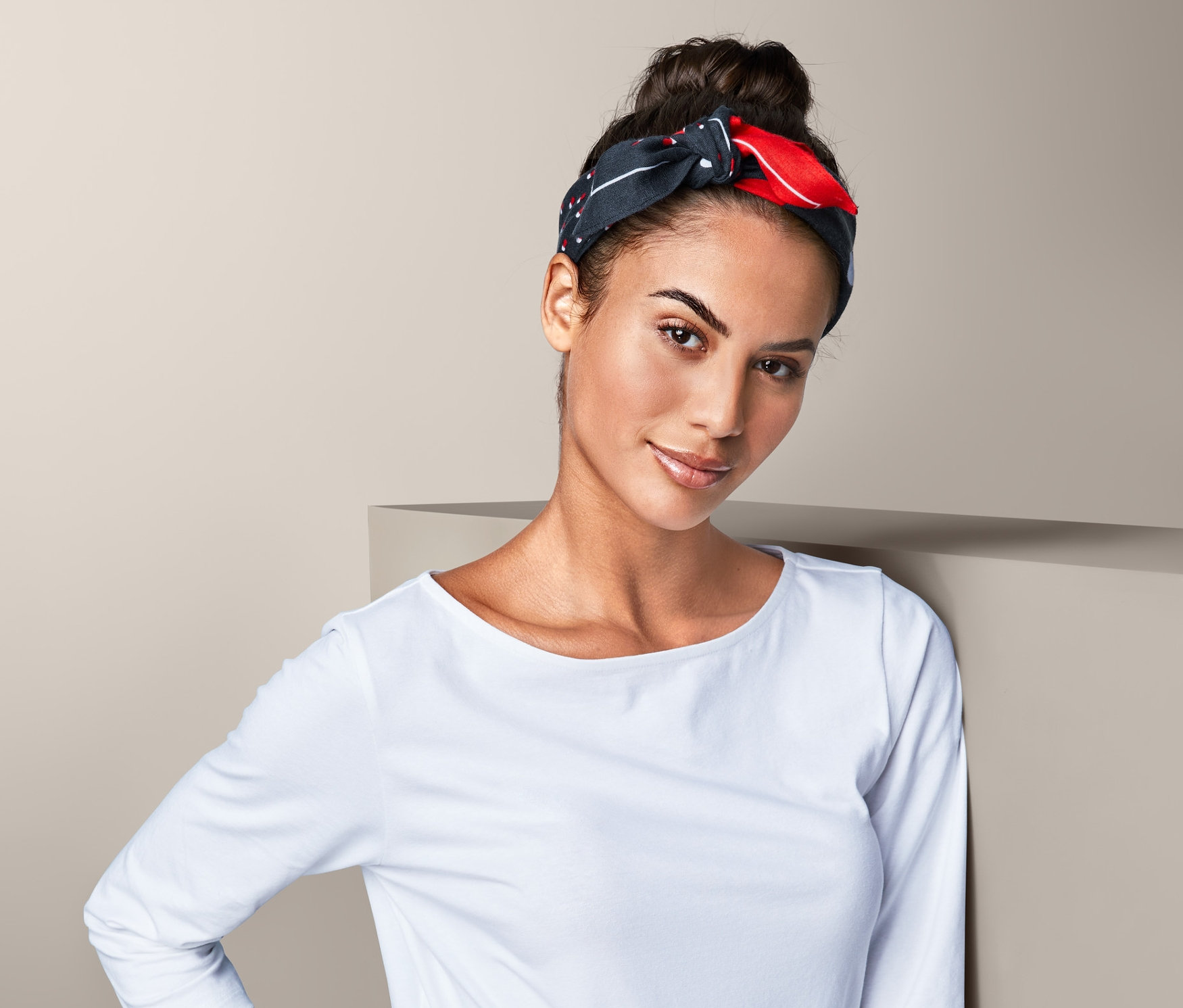 Nő visel sötétkék/piros pöttyös kendőt.