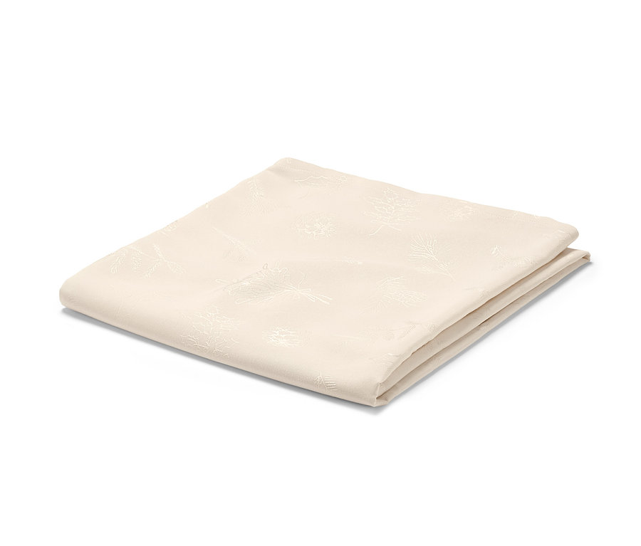 Összehajtott, krémszínű, virágmintás jacquard asztalterítő.