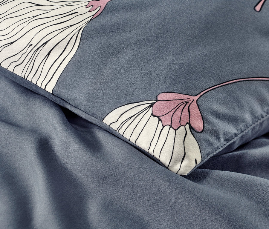 Egy sötétkék, virágmintás mikroszálas ágynemű részlete.