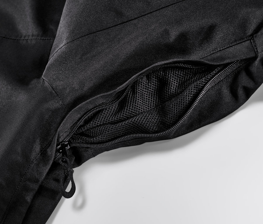 Egy fekete síkabát részlete cipzárral és hálós zsebbel.