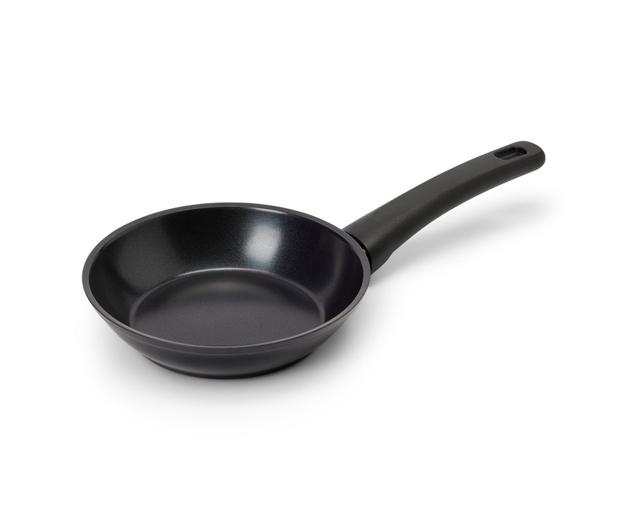 Fekete, tapadásmentes mini serpenyő fekszik a fehér felületen.