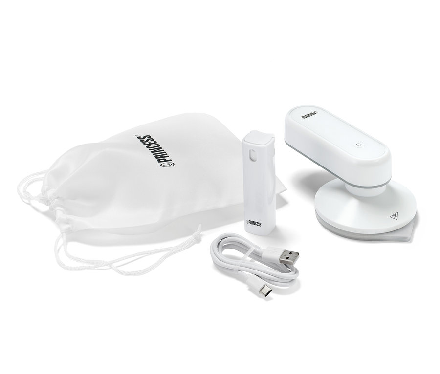 Egy Princess úti vasaló külső akkumulátorral, egy töltőkábel és egy fehér szövet tok van kiterítve.