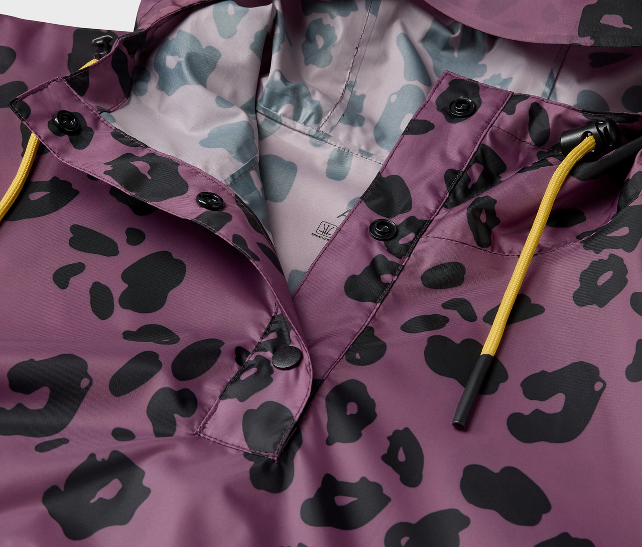 Lila kapucnis kabát fekete állatmintával részlete.