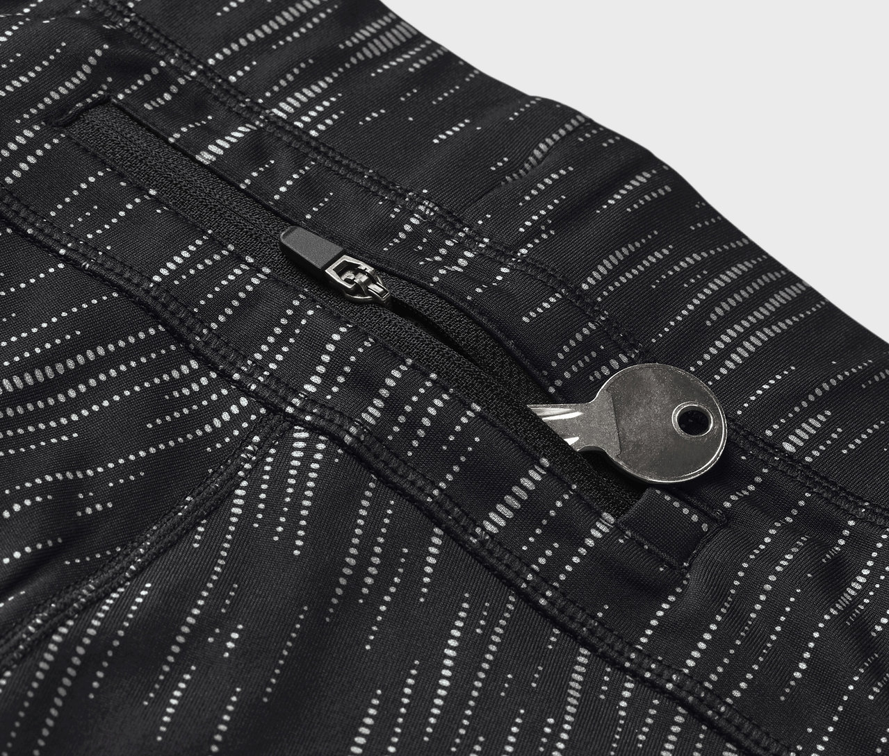 Fekete, mintás leggings részlete, kulcs a cipzáras zsebben.