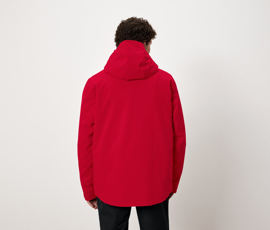 Egy férfi hátulról látható, piros kapucnis kabátot visel.