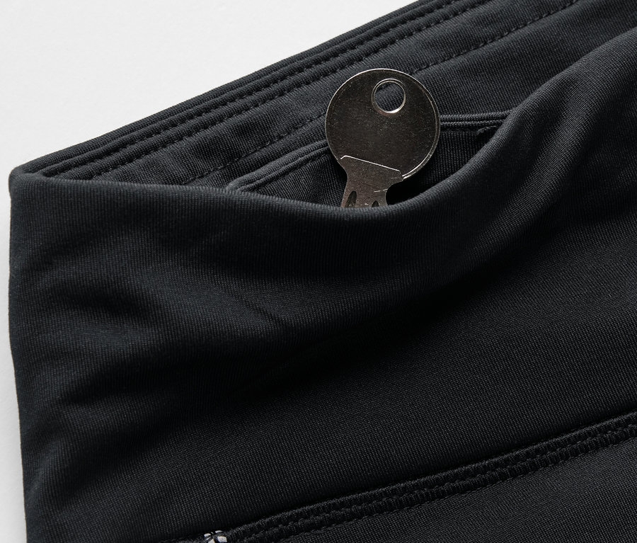 Fekete leggings részlete, kulccsal a zsebben.