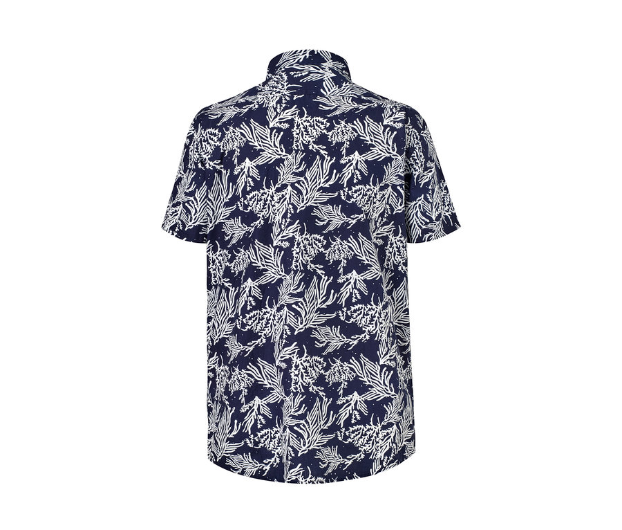 Egy sötétkék alapon fehér levélmintás, rövid ujjú ing részletének fényképe.