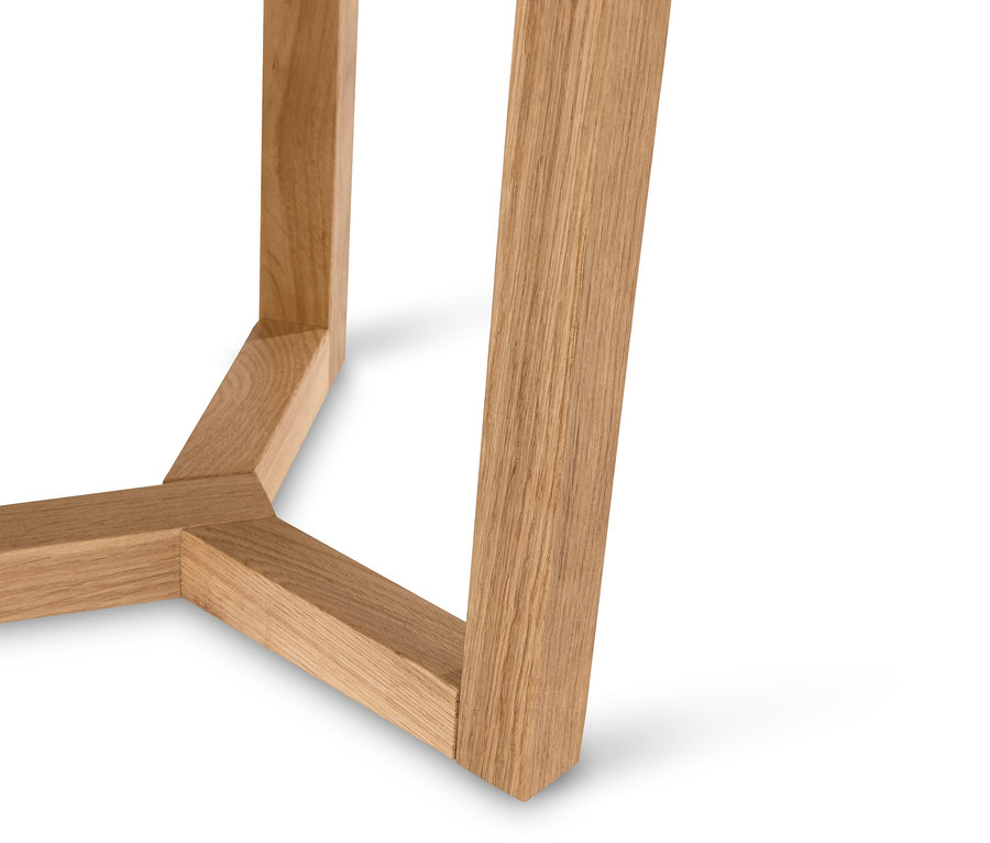 Egy fa asztal lábának részlete fehér háttérrel.