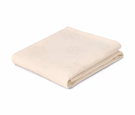 Hópelyhes, összehajtott, krémszínű jacquard asztalterítő.