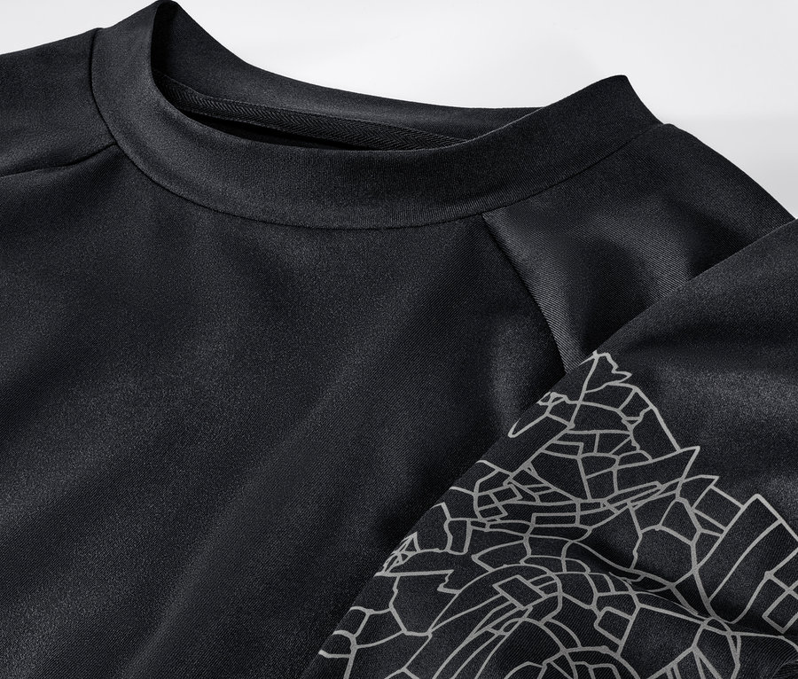 Fekete színű, fényvisszaverős női hosszú ujjú funkcionális felső részlete.