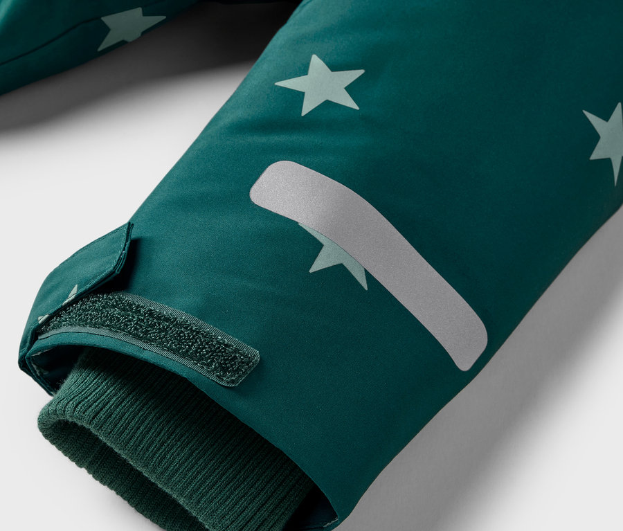 Egy kabátuj részlete csillagokkal és tépőzárral.