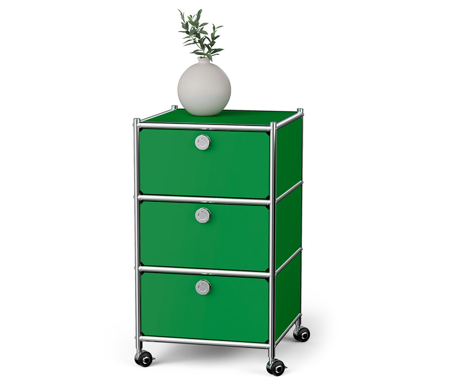 Egy zöld »CN3« görgős tároló 3 fiókkal. A tetején egy fehér váza áll.