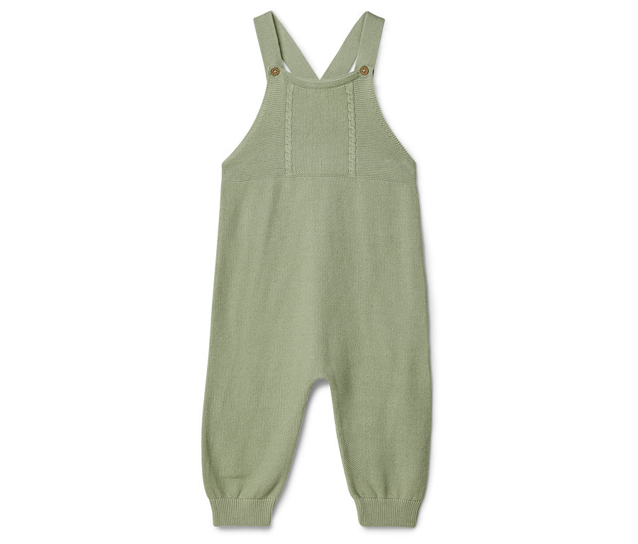 Egyetlen világoszöld kötött babaoverall fekszik egy fehér háttéren, pántokkal.