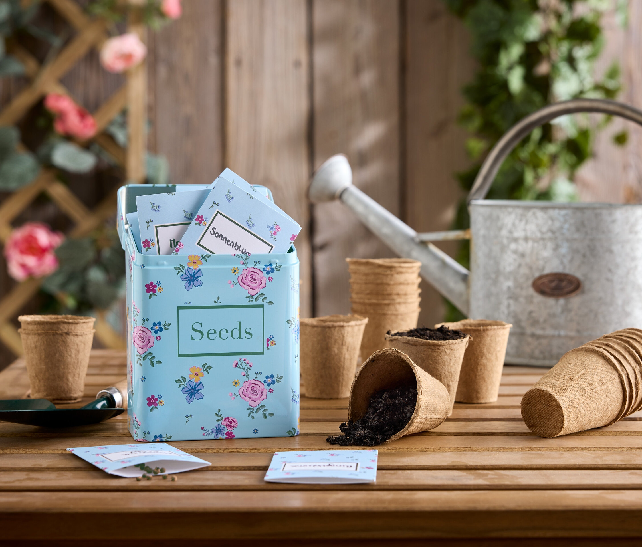 Virágmag készlet fa asztalon, horganyzott öntözőkannával és palántázó edényekkel.