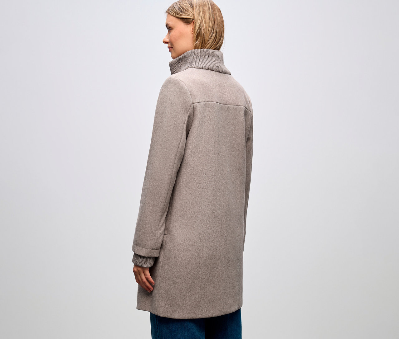 Profilból látható nő Street One rövid kabátban és kék farmerban.