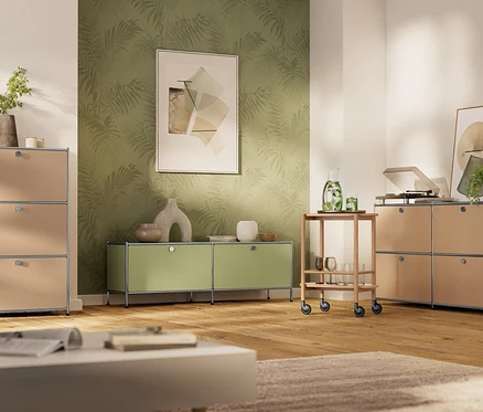 Nappali bézs és lime zöld USM bútorokkal, köztük polcokkal és egy tálalókocsival, fa padlón.
