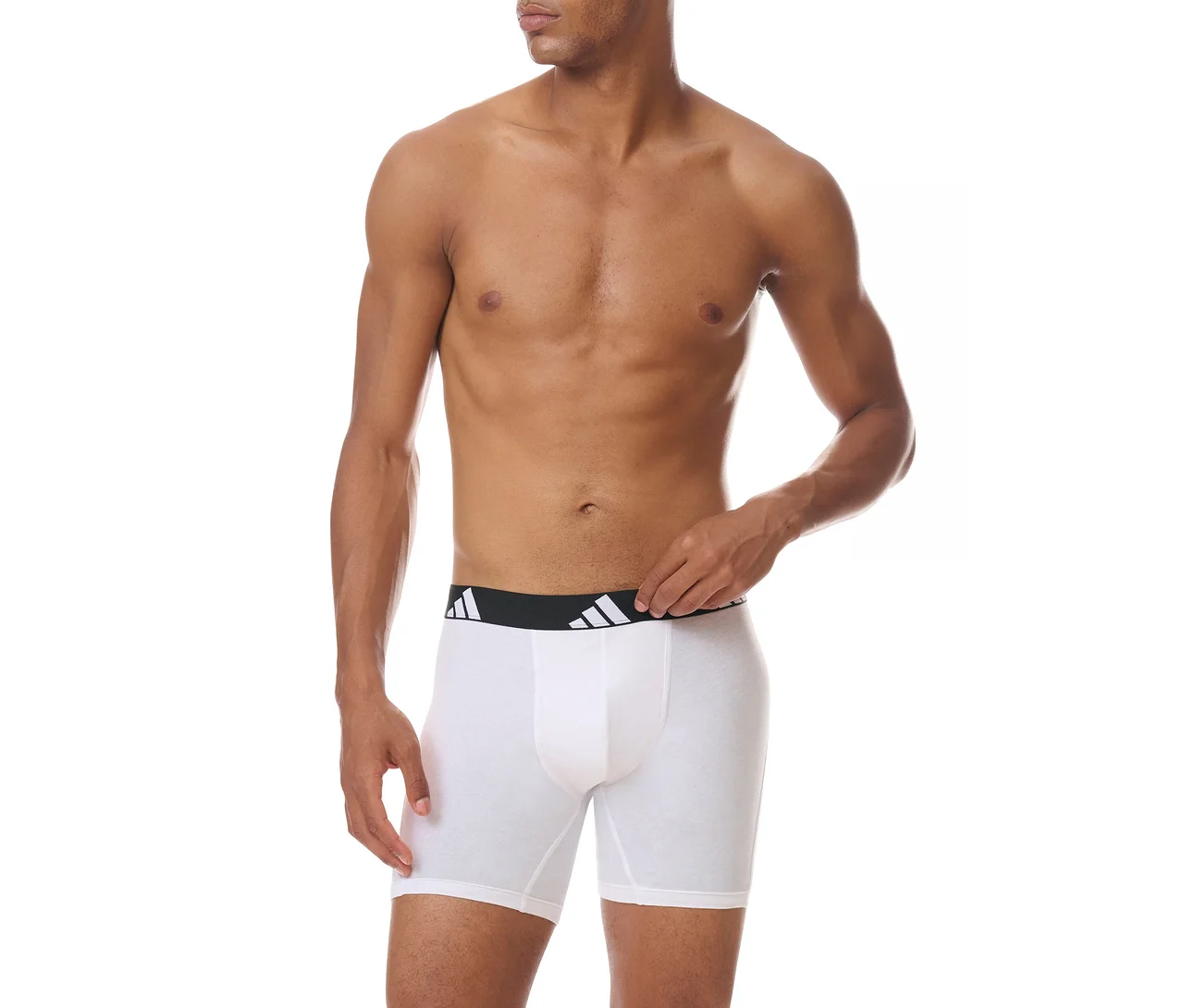 Felsőtestén meztelen férfi fehér boxeralsót visel fekete Adidas logós derékpánttal, jobb kezével igazítja a derékpántot.
