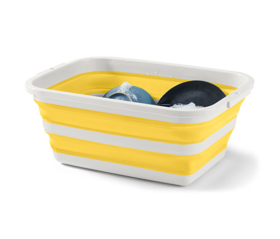 Egy sárga-fehér összecsukható szennyestartó kosár mosogatószerrel és edényekkel.