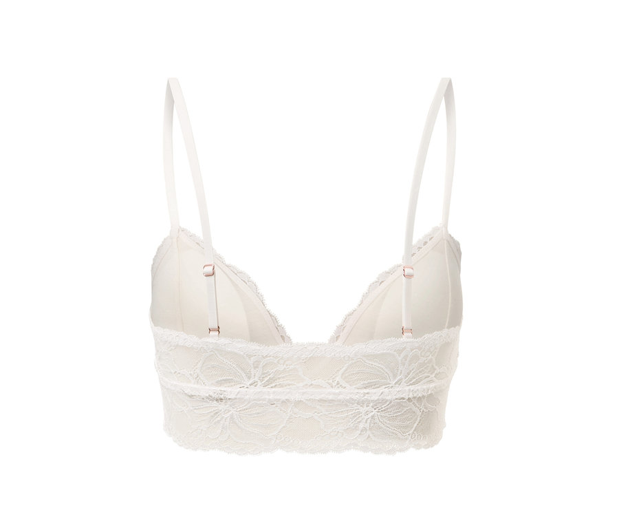 Egy krémszínű, csipkés női bustier melltartó részletgazdag képe, állítható pántokkal.